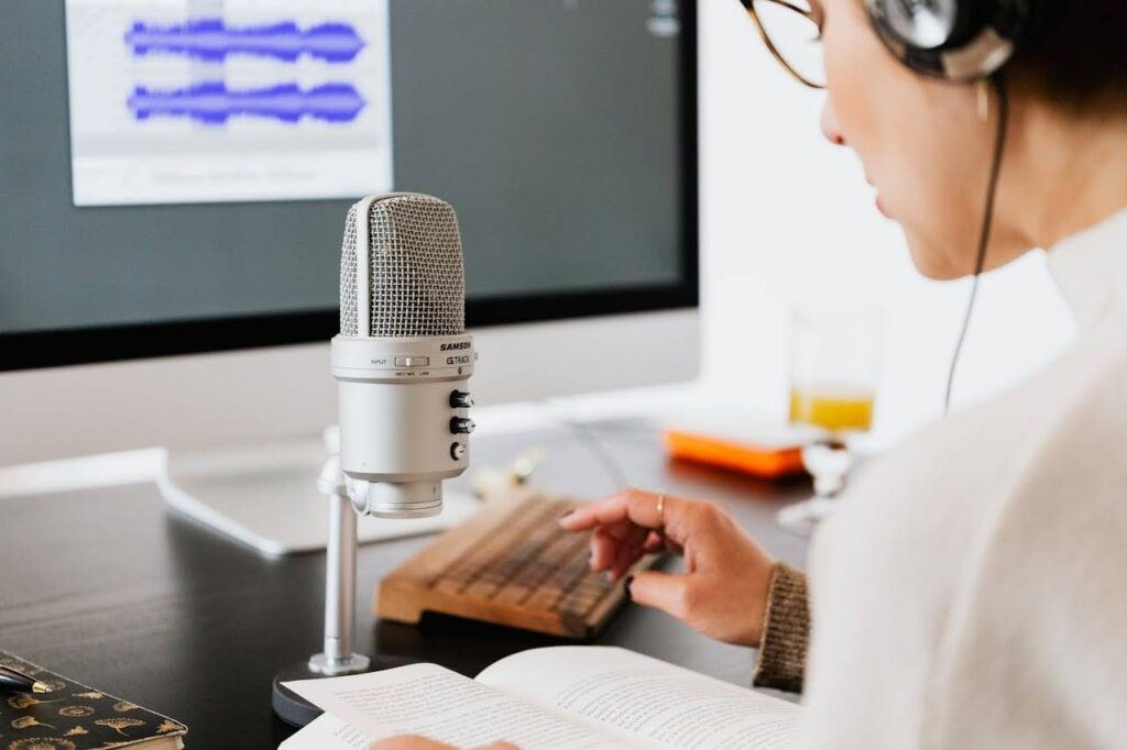 Female voice actor wearing headphones while recording character lines for a video game in a studio