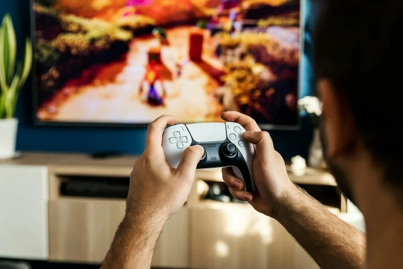 Player holding a controller, navigating through a compelling storyline and interactive world.
