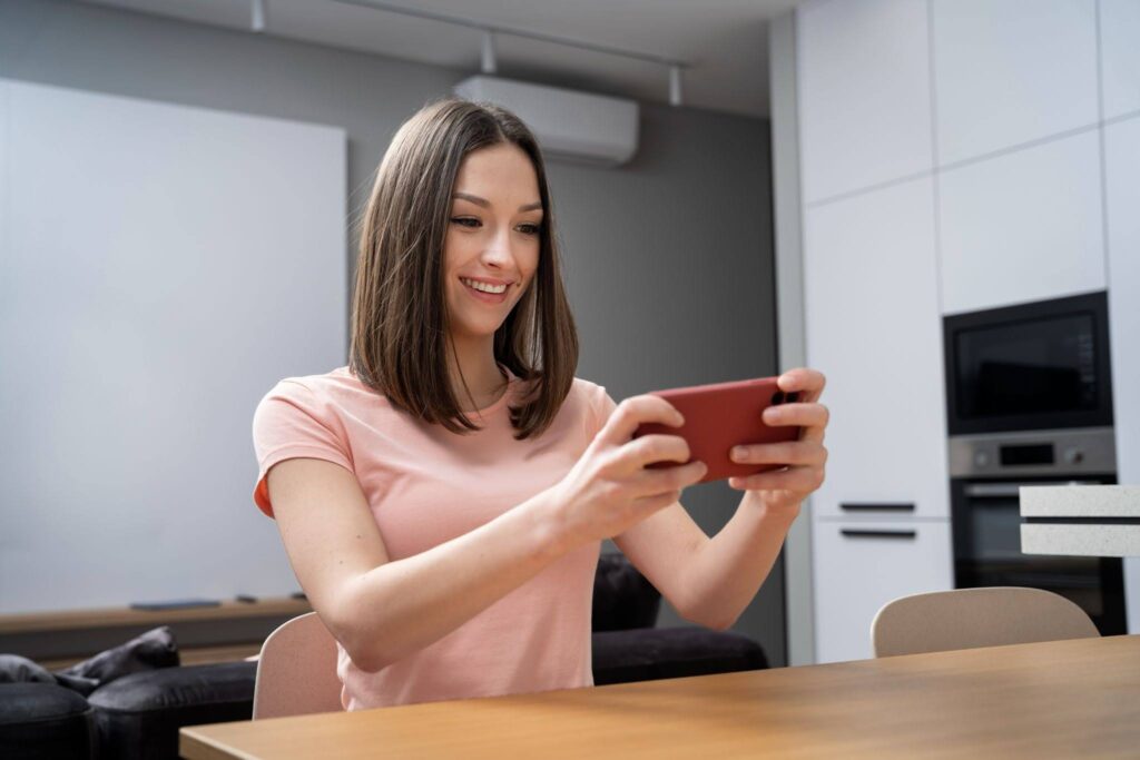 A woman enjoying a localized mobile game simulator on her phone