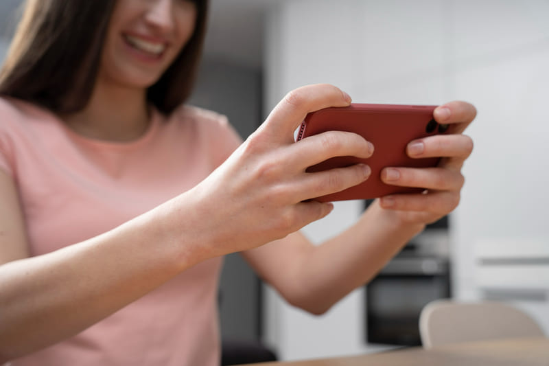 A woman using her phone to play a culturally adapted mobile game.
