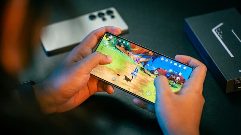 A gamer is playing a highly visual mobile game with on-screen graphics that represent localized cultural elements and a captivating layout.
