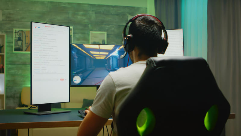A gamer wearing headphones is completely engrossed in AI-powered gameplay that features good localization.