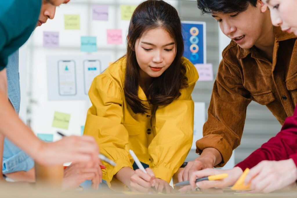 A group of young developers reviewing poor game monetization strategies.