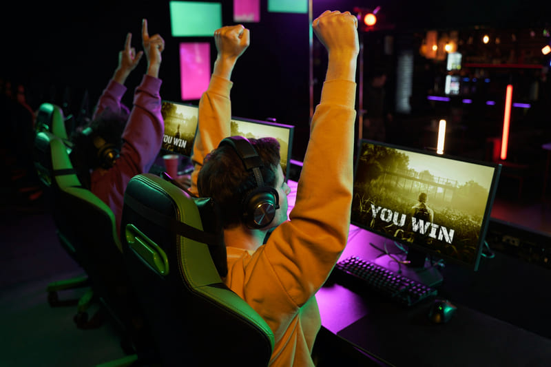 Competitive gaming setting in which a team celebrates victory while playing one of 2026's most popular games.