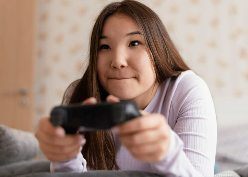A female gamer concentrating on a game that reflects local cultural values.