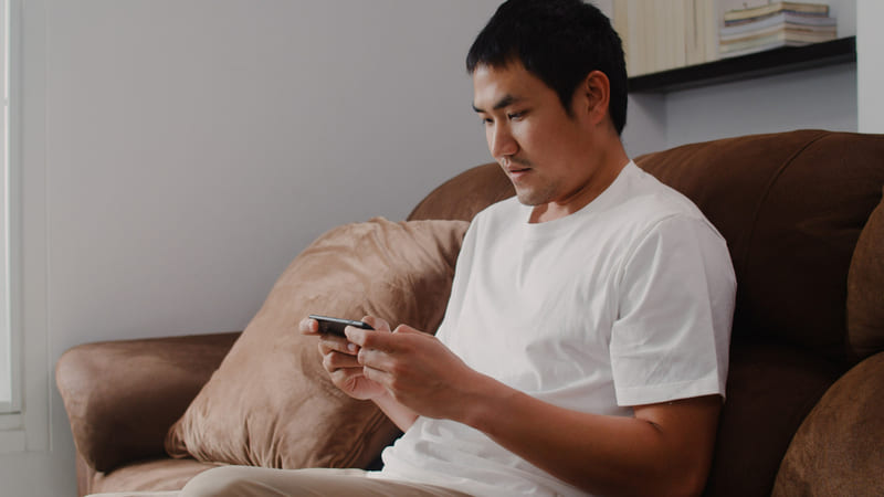 A player engages in mobile gameplay on a modern phone.
