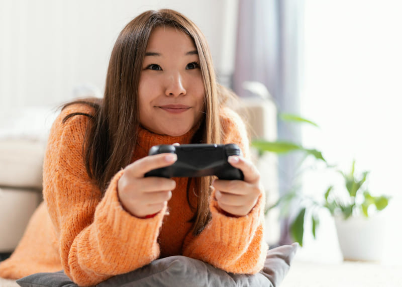 A female gamer is having fun playing a video game with a controller.