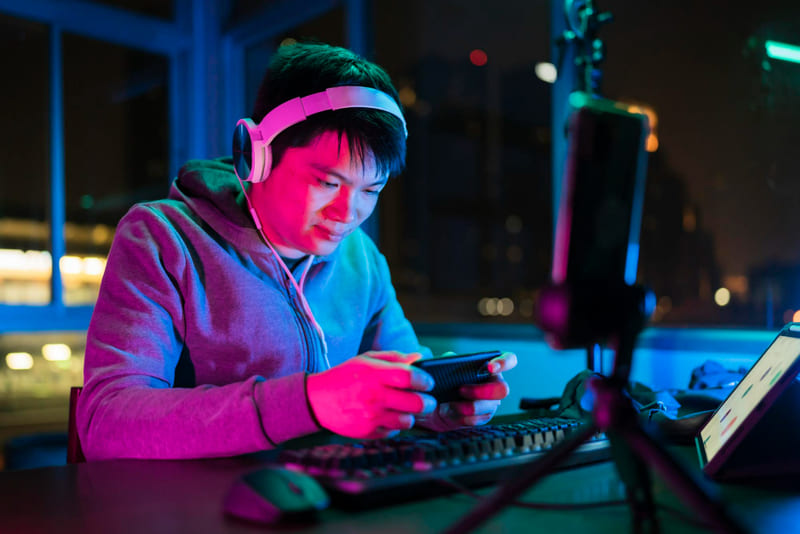 A gamer wearing headphones streams and shares his gameplay with online audiences.