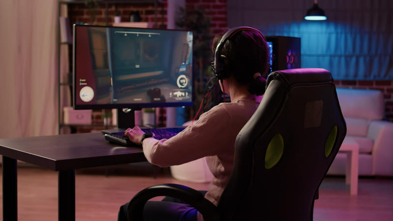 A gamer on a desktop is immersed in a PC open-world game.