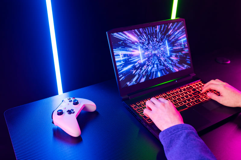 A gaming laptop with a controller that showcases future gaming trends in 2026.