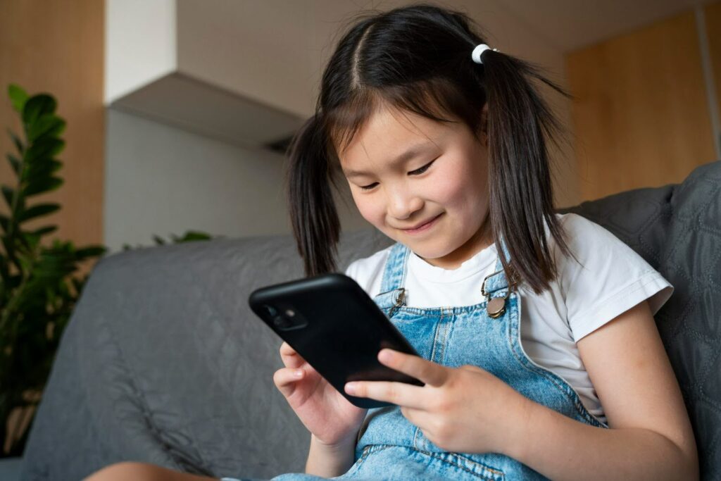 Illustration of a kid playing a mobile game with safety regulations.
