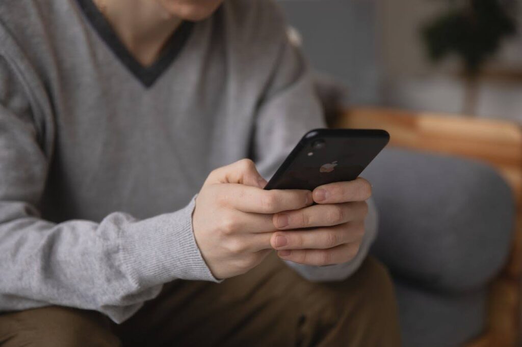 close-up of a person focused on mobile gaming while platform regulations evolve in their region.