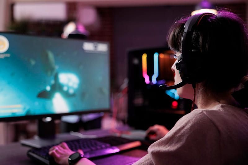 Close-up of a gamer at a computer exploring new gaming innovative genres.