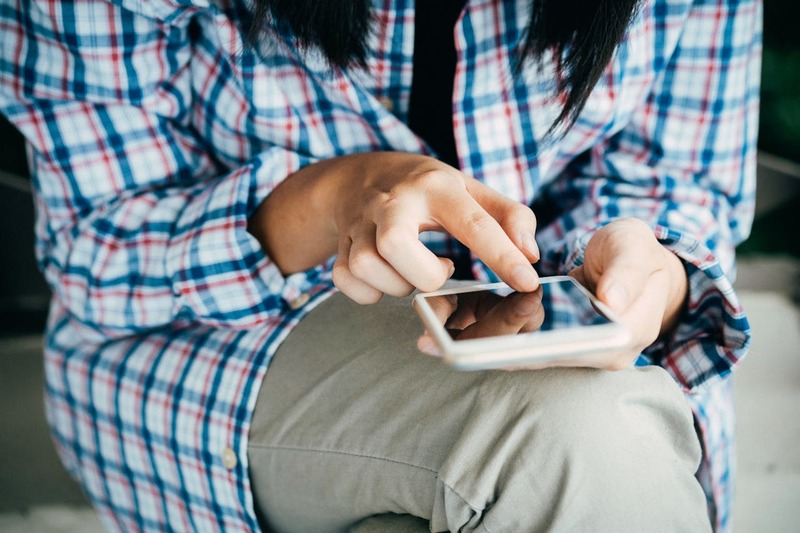 A person using a mobile device, highlighting how players are affected by platform regulation.