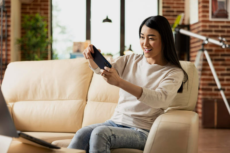 A woman playing a video game on her smartphone, completely focused and immersed in the gameplay.