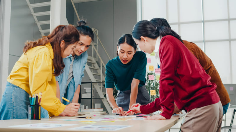 Illustration displays women in the development team brainstorming ideas for a game project.