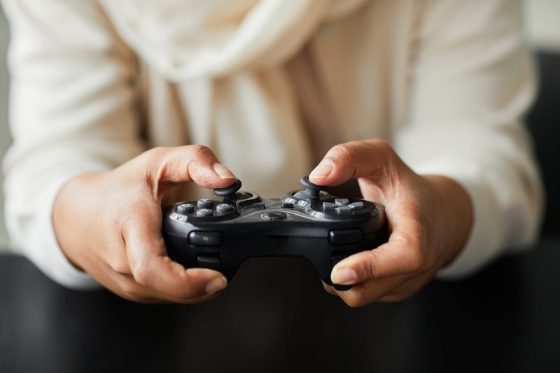 An illustration of a player engaged in a video gaming experience that complies with Indonesian content rating guidelines.