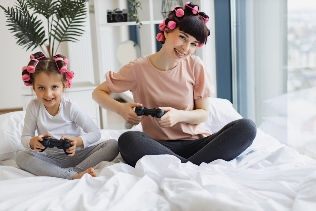 A mother and daughter play video games together, showing how age labels promote safe and appropriate games for young players.