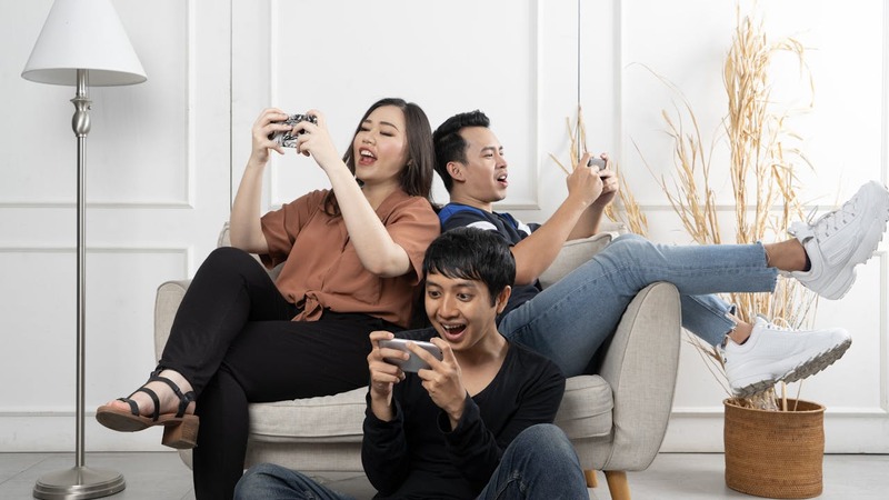 An illustration of Malaysian gamers using smartphones to play mobile games together.