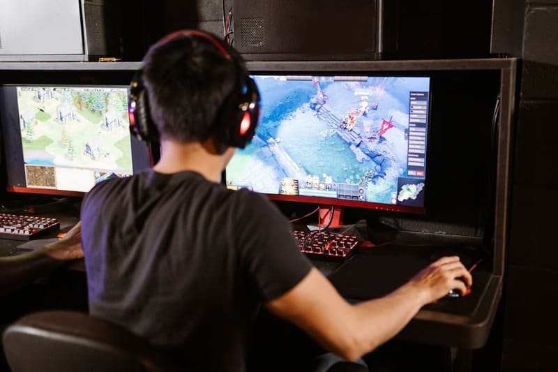 A gamer participates in a MOBA game, teaming up with other players to destroy opponents.