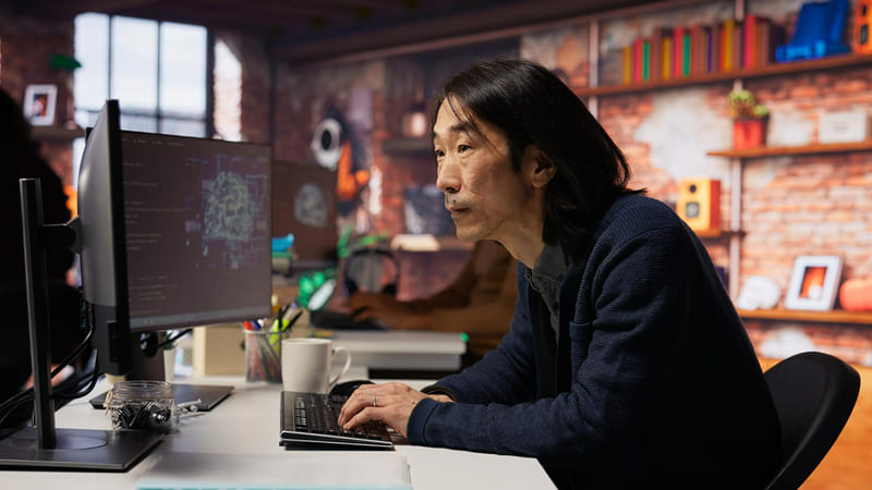 A game developer using a multi-screen computer to synchronize IGRS systems with international privacy frameworks.