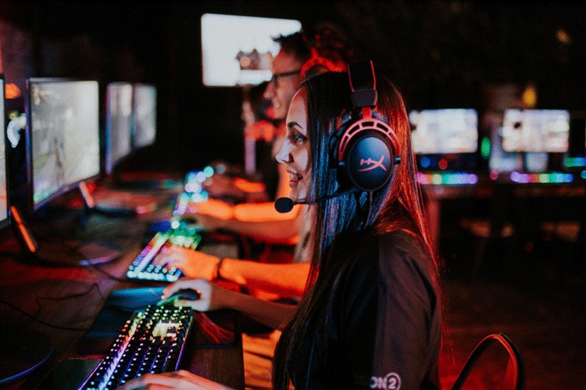 Gamers enjoying PC games at an internet cafe, illustrating how playing together is a community-building social ritual rather than just a habit.