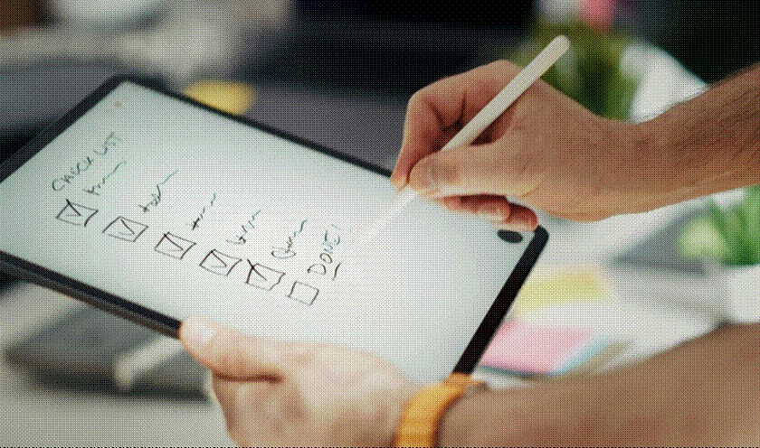A marketing team ticking off boxes on a tablet screen to ensure game marketing assets are culturally accurate.