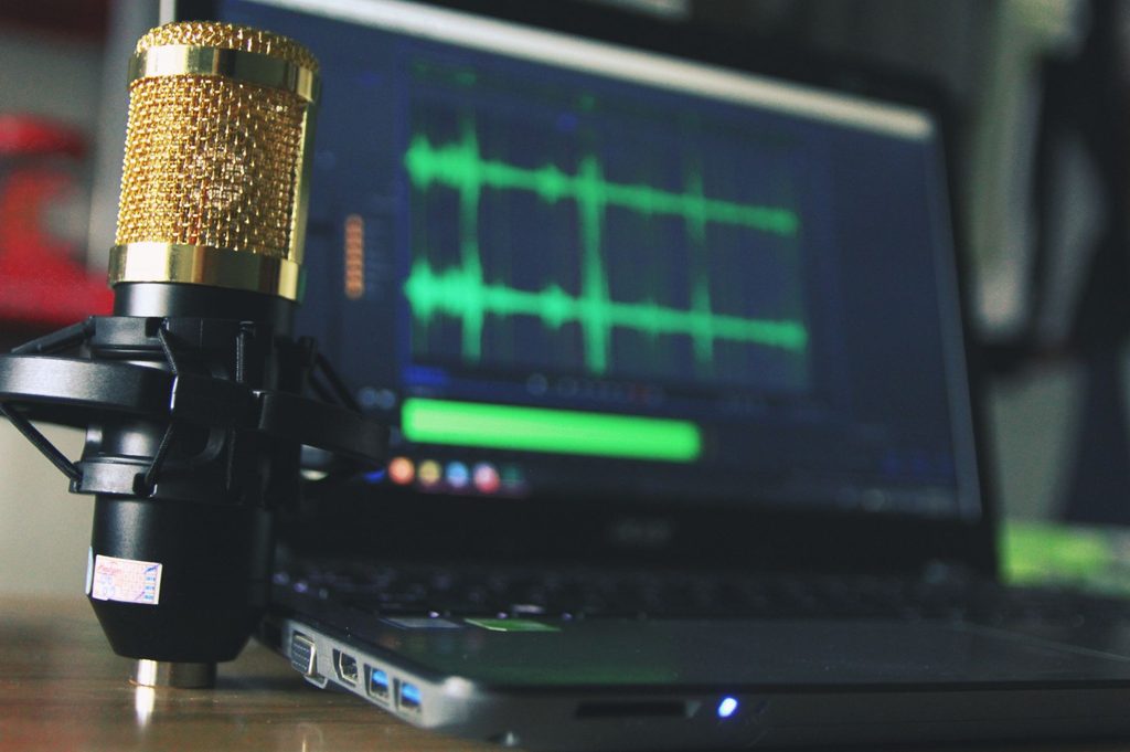 An illustration of studio microphone and audio editing software used to create localized game audio.