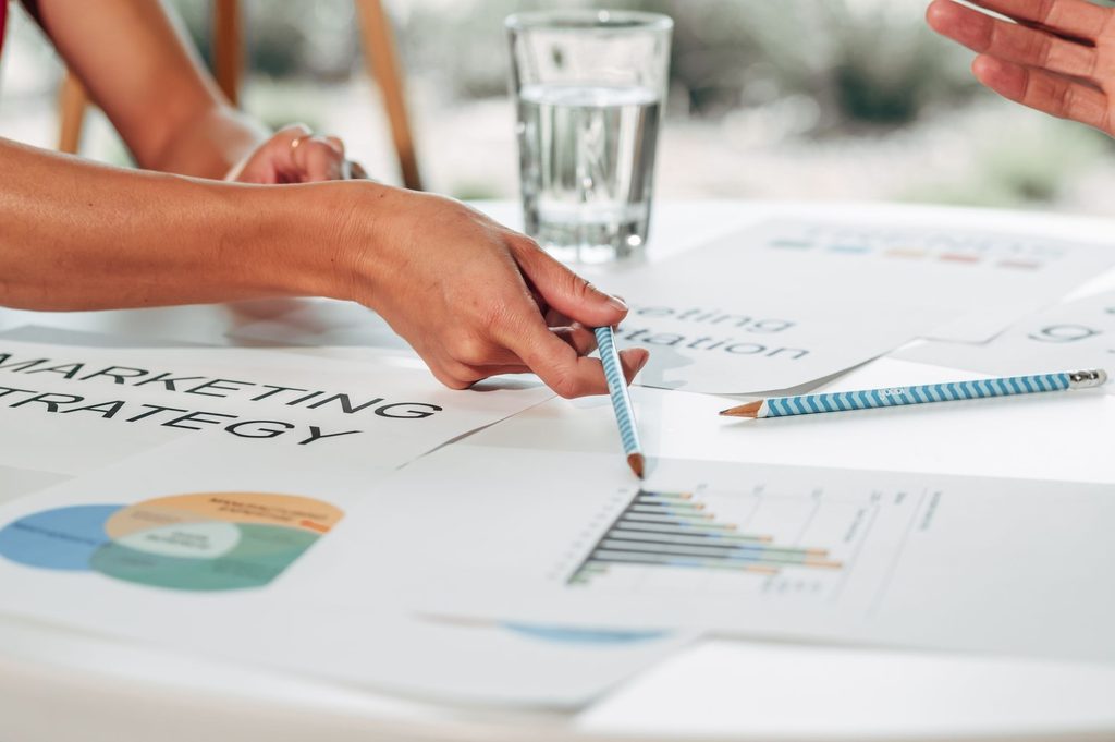 A marketing team reviews charts and data to develop a region-focused game localization strategy.